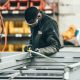 Man measuring metal and reading measuring tape